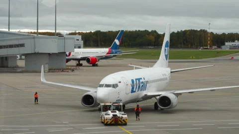 Tractor pulling Boeing 737 of UTair Stock Footage 284560103