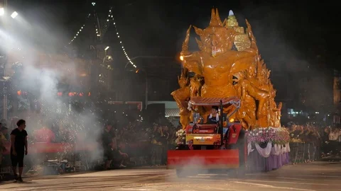 Tractor pulling car with candle at parade,Ubon Ratchathani,Candle Stock Footage 81068589