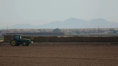 Tractor pulling Discs with Hay Bales Stock Footage 94643197