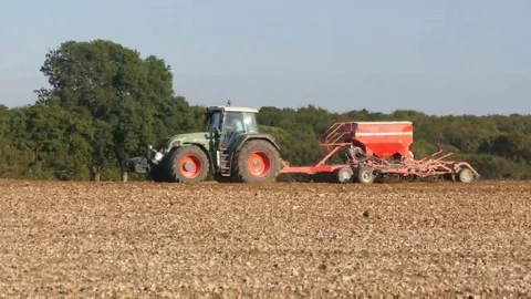 Tractor pulling fertilizer trailer in field, Wiltshire, UK Stock Footage 69093024