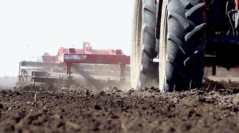 Tractor pulling land cultivating machine Stock Footage 49536292
