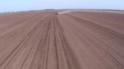 Tractor pulling land cultivating machine for sowing preparation. Aerial footage. Stock Footage 80045441