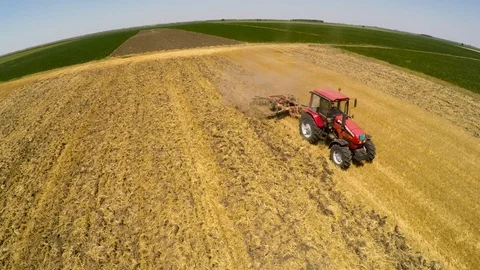 Tractor pulling land cultivating machine. Aerial footage. Stock Footage 88413701