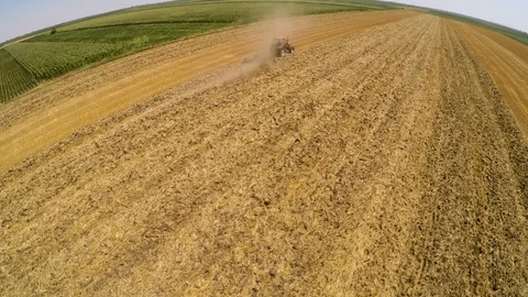 Tractor pulling land cultivating machine. Aerial footage. Stock Footage 88480451