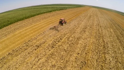 Tractor pulling land cultivating machine. Aerial footage. Stock Footage 88480452