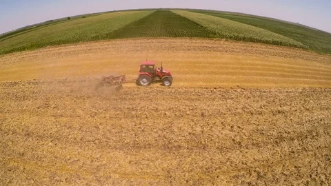 Tractor pulling land cultivating machine. Aerial footage. Stock Footage 88480629