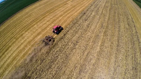 Tractor pulling land cultivating machine. Aerial footage. Stock Footage 88876515