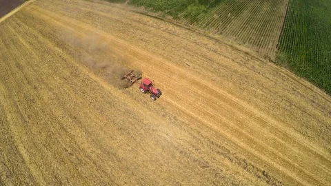 Tractor pulling land cultivating machine. Aerial footage. Stock Footage 88878347