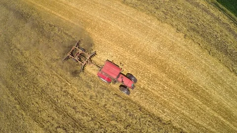 Tractor pulling land cultivating machine. Aerial footage. Stock Footage 88884150