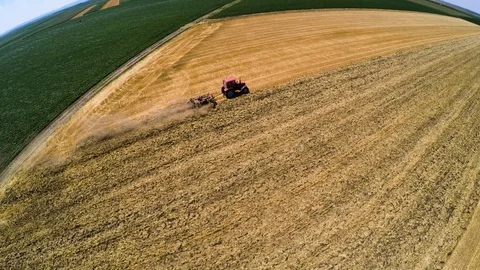 Tractor pulling land cultivating machine. Aerial footage. Stock Footage 88889904