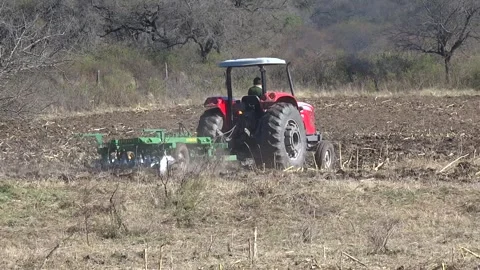 Tractor pulling a plow in mountainous terrain Stock Footage 324800529