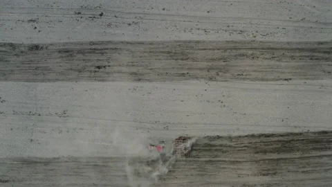 Tractor pulling plow, throwing dust in air. Combine harvester at wheat field Stock Footage 133920881