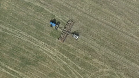 Tractor pulling seeding machine on open field in Canada, aerial Stock Footage 157022050