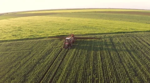 Tractor pulling a sprayer machine in wheat fields. Stock Footage 50284928