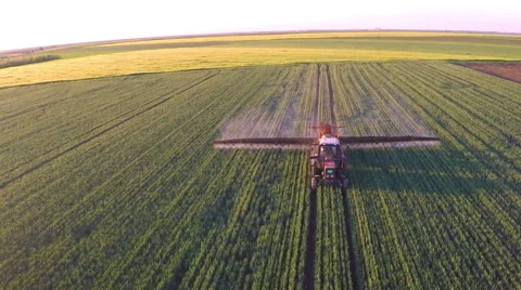 Tractor pulling a sprayer machine in wheat fields. Stock Footage 50286513