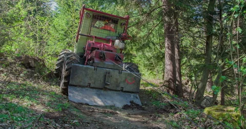 Tractor is pulling three tree trunks Stock Footage 62682681