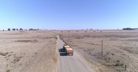 Tractor pulling trailer laden with maize along dirt road in the dry season Stock Footage 93486611