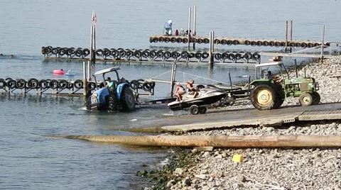 Tractor pulls a boat out of the water .  beach on the Kinneret. Stock Footage 68995027