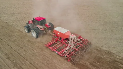 Tractor pulls a combined crop unit across the prairie Stock Footage 155508754