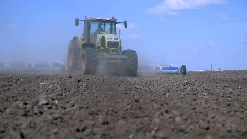 The tractor pulls the cultivator for tillage. Processing of land Stock Footage 88778645