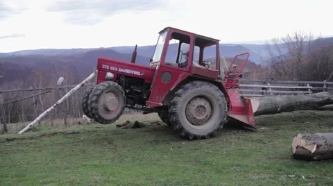 Tractor that pulls a cut tree trunk in the forest with a cable. Because weigh Video stock 59939283