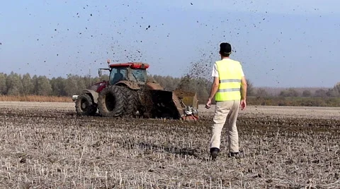 Tractor pulls a machine that cuts the channels in the field Stock Footage 48361289