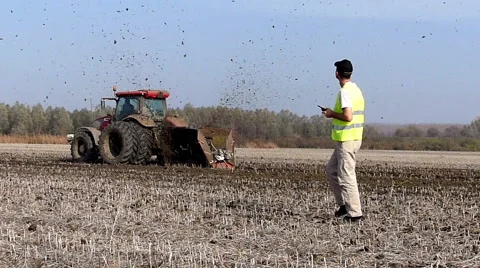 Tractor pulls a machine that cuts the channels in the field Stock Footage 48361436