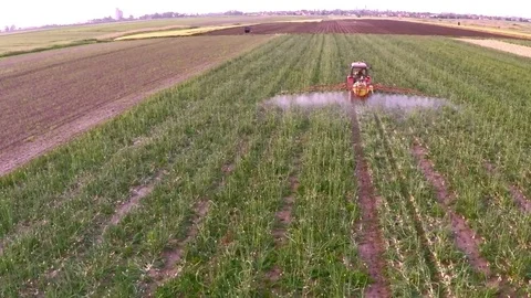 The tractor pulls a machine for spraying onion. Aerial footage. Stock Footage 83553220