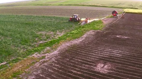 The tractor pulls a machine for spraying onion. Aerial footage. Stock Footage 83553274