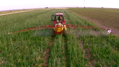 The tractor pulls a machine for spraying onion. Aerial footage. Stock Footage 83553822