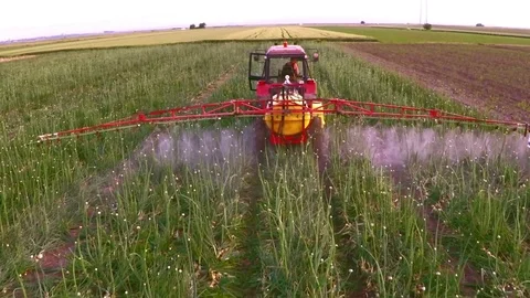 The tractor pulls a machine for spraying onion. Aerial footage. Stock Footage 83556384