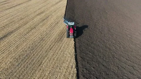 Tractor pulls a plow across a farm field. preparation of the field before sowin Stock Footage 160437465