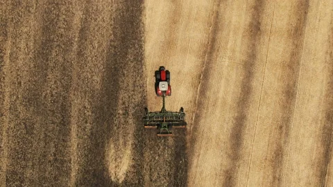 Tractor pulls a plow across a farm field. preparation of the field. Drone view Stock-Footage 169958948