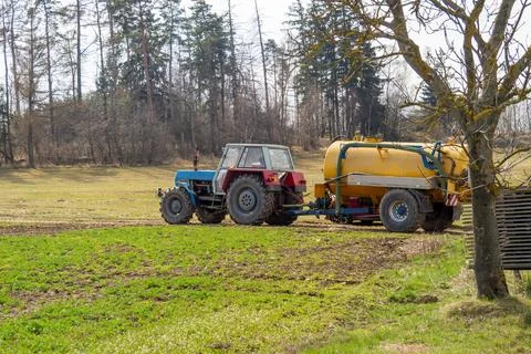 Tractor pulls yellow sprayer across green field, March 24, 2026, Velká Biteš Stock Photos