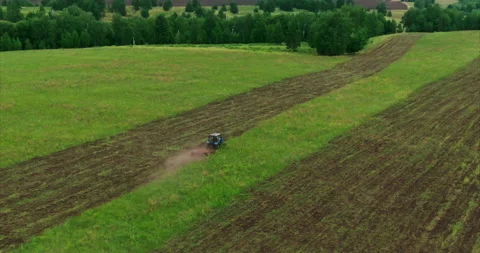 Tractor removes grass from the soil in the field, preparing the soil for sowing Stock Footage 136432100