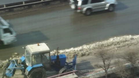 Tractor removes snow in reverse Stock Footage 125457200