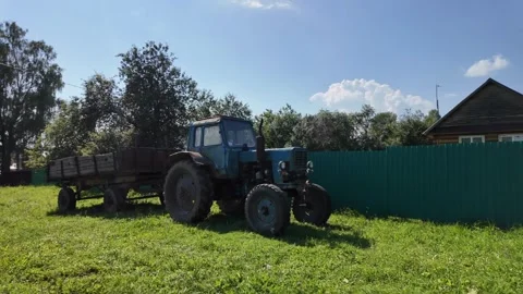 Tractor rests peacefully, Quiet rural scene with equipment and nature Stock Footage 322902895