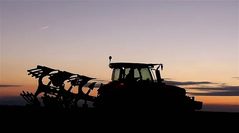 Tractor reverses plow in sunset Stock Footage 48846237