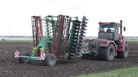 Tractor rides on the field with the system of planting beans Stock-Footage 78673380