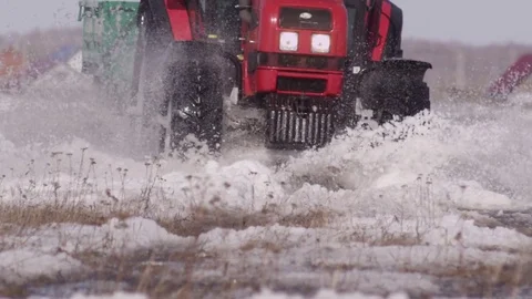 Tractor rides through the snow and water Stock Footage 84214573