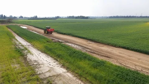 Tractor on road the fields after the rain 스톡 동영상 125912111