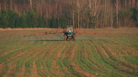 Tractor with rod sprayer on a field with young shoots 스톡 동영상 196279487