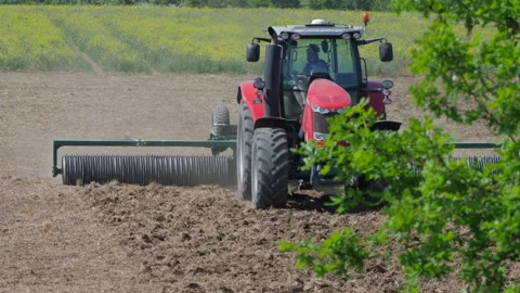 Tractor rolling field Stock Footage 130673044