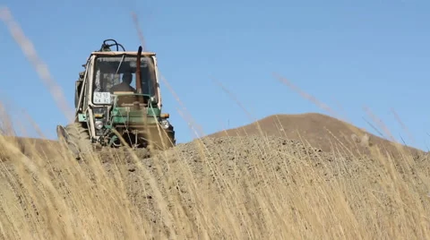 Tractor rowing ground in front of him Stock-Footage 60563495