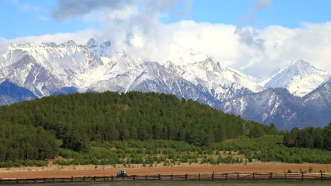 Tractor running in the field against the backdrop of the mountains in the spring Stock Footage 87640154
