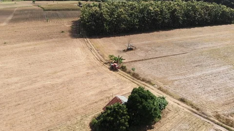 Tractor running through empty crop field Видео 98345728