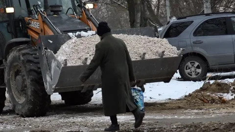 Tractor scoops rubble into a bucket for backfilling the heating pipeline Stock Footage 282571119