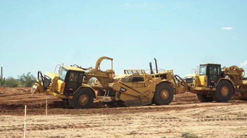 Tractor Scrapers connected to each-other moving earth Stock Footage 217487951