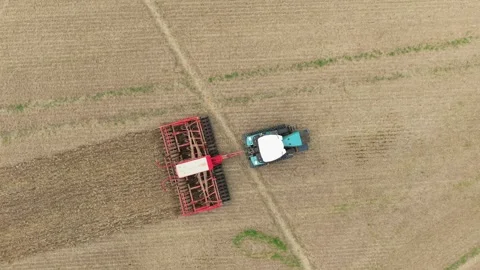 Tractor with seed drill working across cultivated farmland. Agricultural Stock Footage 345501188