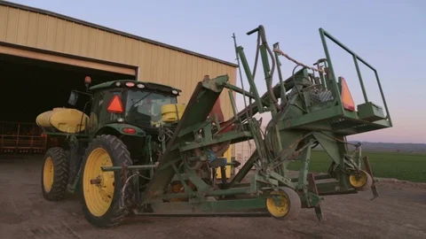 Tractor with Seed Planter Rig Backing out of Shop Stock Footage 101972530